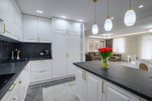 Large black and white expensive well-designed modern kitchen in studio interior, black marble