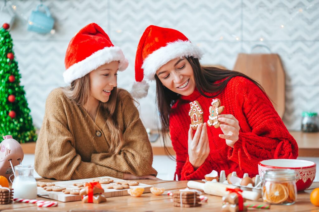 Happy family mother and daughter bake cookies for Christmas