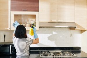 Woman cleaning kitchen cabinets